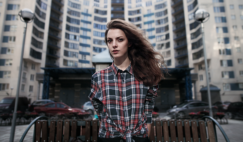 Девушка на фоне многоэтажного дома. Фото Ефима Шевченко