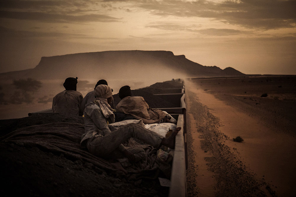 Молодой Мухаммед Салам и его коллеги путешествуют на вагонах с железной рудой из шахтёрского городка Зуэрат посреди Сахары в Нуадибу. Место съёмки: Мавритания. Номинация: National Awards, Испания, 1 место. (Rafael Gutierrez Garitano/2014 Sony World Photography Awards)