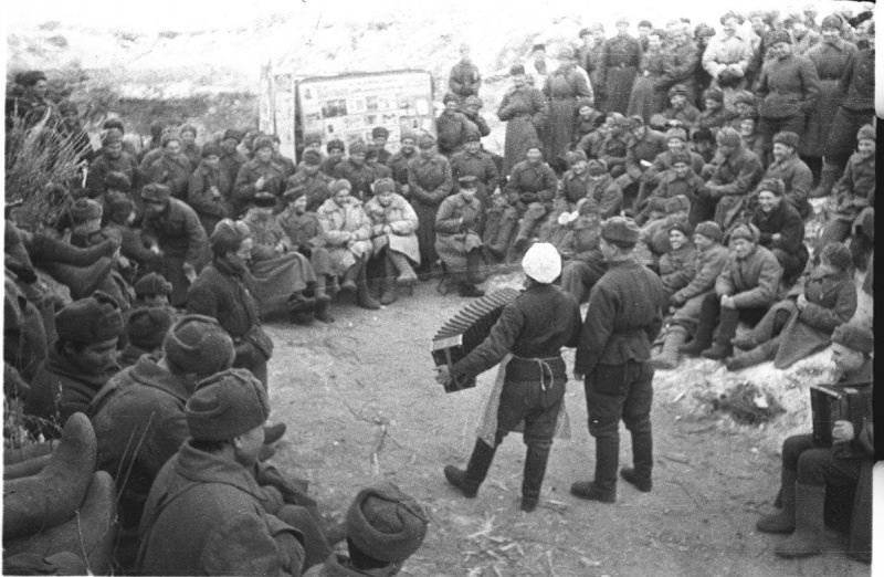 Советские солдаты и офицеры слушают выступление гармониста в перерыве между боями под Сталинградом. 1943 год . Наталья Боде