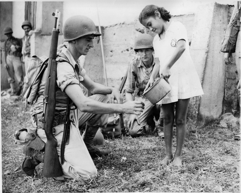 Панамская девочка дает напиться воды американскому солдату во время учений армии США в Панаме в 1942 году.