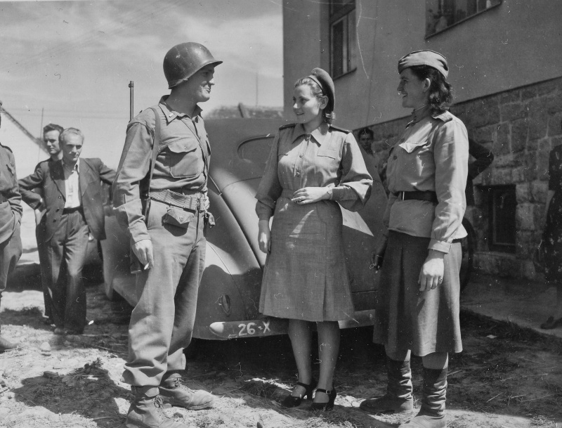 Лейтенант 26-й пехотной дивизии армии США общается с советскими девушками-офицерами медицинской службы. Чехословакия. 1945 год
