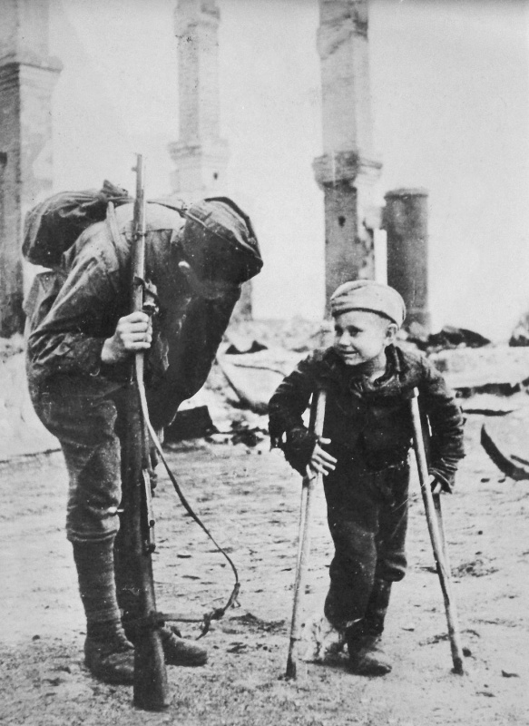 Неизвестный боец Красной Армии беседует с десятилетним Володей Лукиным, родителей которого немцы угнали в Германию. Лишившись крова, мальчик отморозил себе ноги. 2-й Прибалтийский фронт. 1944 год.