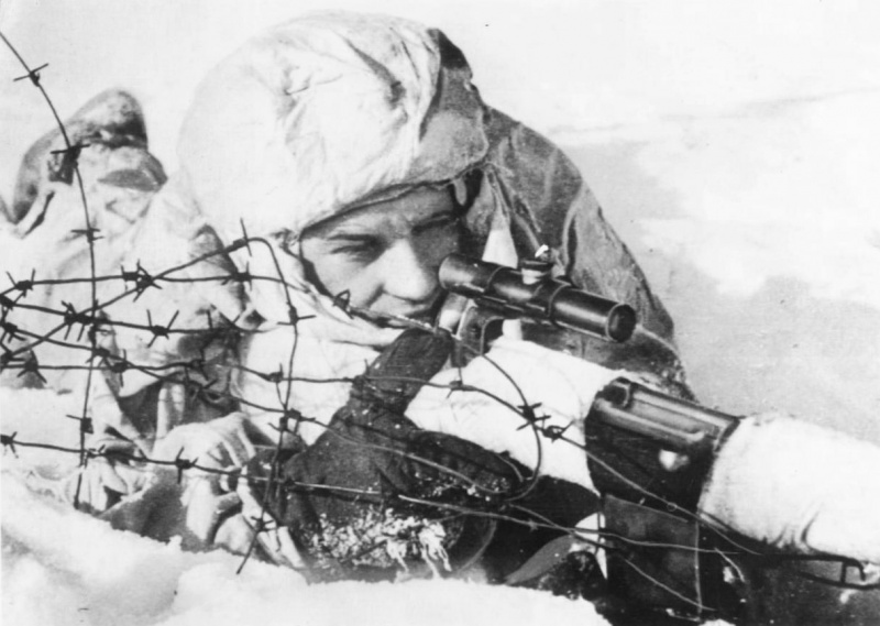 Советский снайпер сержант Жидков, вооруженный самозарядной винтовкой СВТ-40 с оптическим прицелом ПУ, на огневой позиции. Северный фронт. 