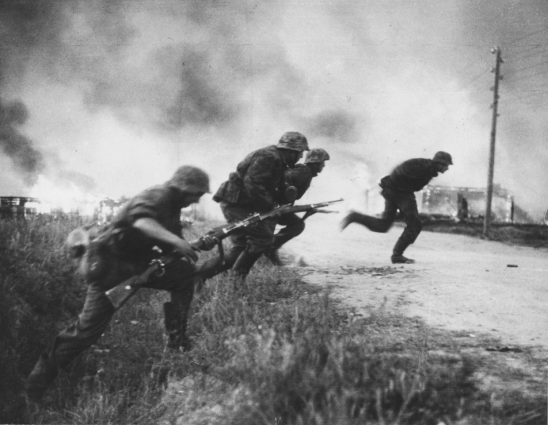 Солдаты дивизии СС «Рейх» перебегают дорогу на фоне горящей советской деревни. 1941. Источник: www.nationaalarchief.nl.