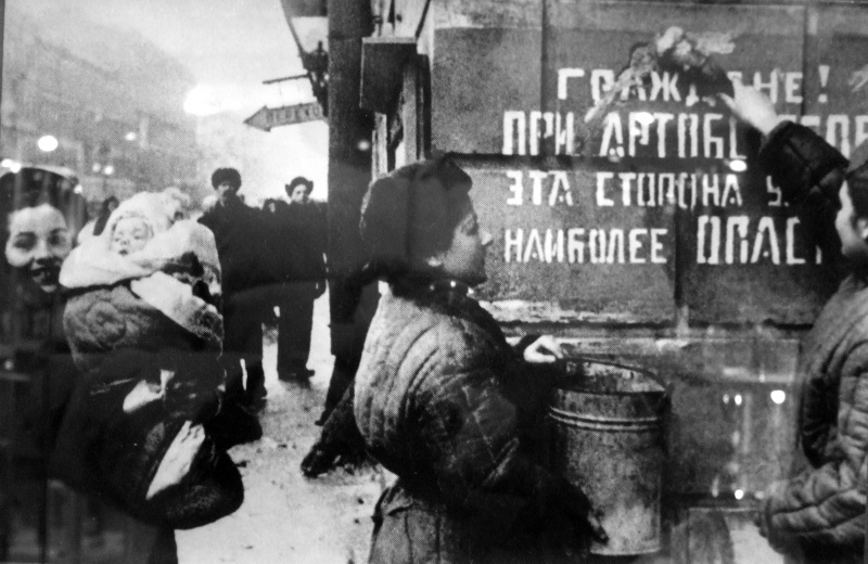 Ленинградцы закрашивают надпись на стене дома, предупреждающую об артобстрелах, после окончательного освобождения города от вражеской блокады. 