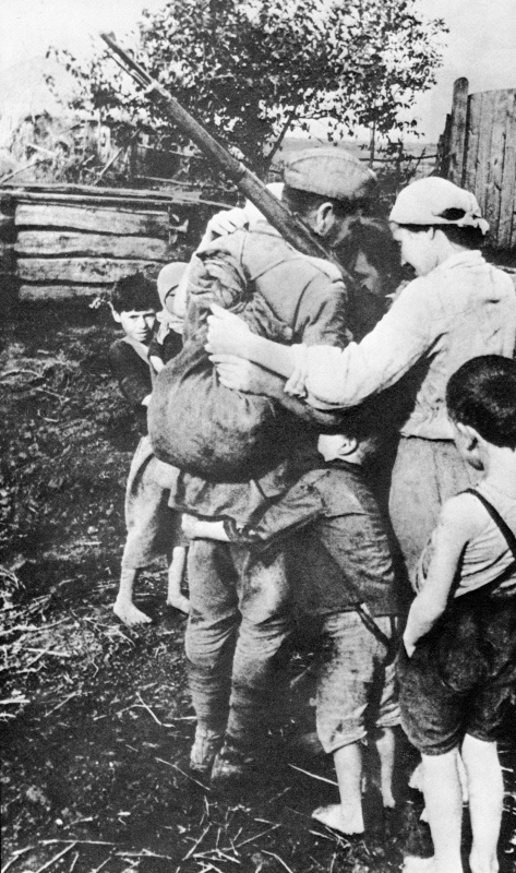 Советский солдат обнимает свою семью после долгого расставания. Авторское название фото: «Мимо родного села». 1943 год. Автор: Олег Кнорринг