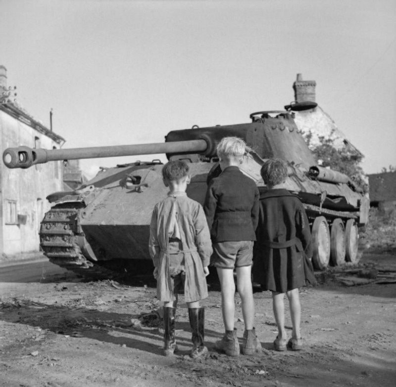 Французские дети смотрят на подбитый немецкий танк Pz.Kpfw. V «Пантера», уничтоженный в Фалезском котле. Нормандия, Франция. 15.08.1944