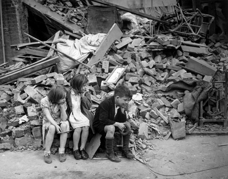 Дети восточного пригорода Лондона у разрушенного здания, сентябрь 1940 года.