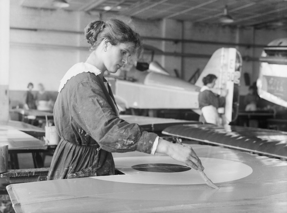 Неизвестный автор. Женщина, рабочая фабрики «Austin Motor Company» в Бирмингеме, рисует круг на крыле самолета «SE5A». Сентябрь 1918. Собрание Имперского военного музея, Лондон
