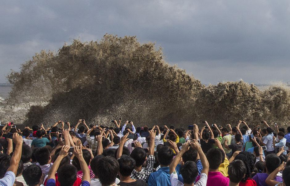 Туристы фотографируют приливные волны, вызванные тайфуном Усаги. Китай. 22 сентября 2013 г. Reuters / Chen Zhongqiu.