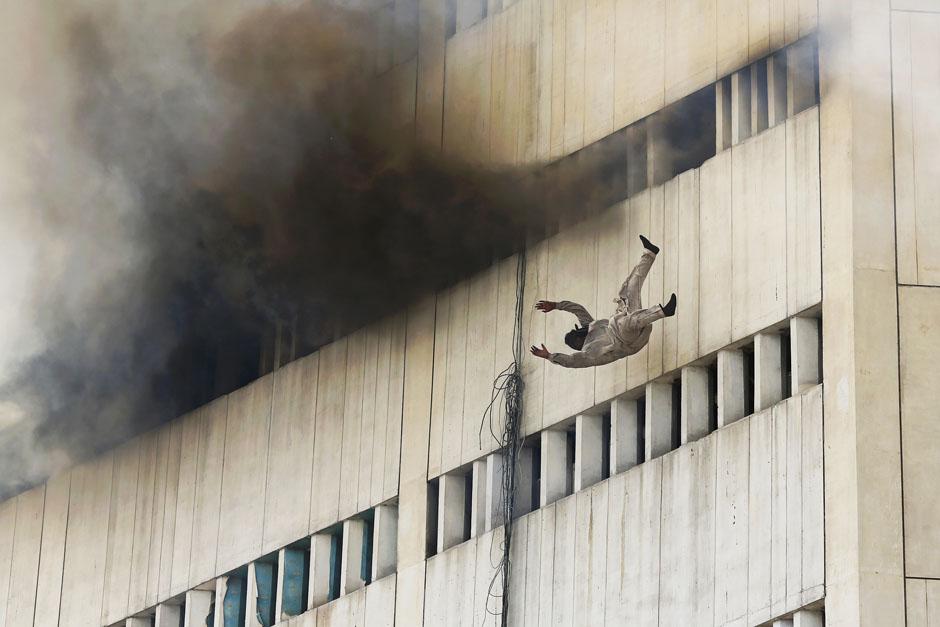 Мужчина падает из окна горящего здания. Лахор. 9 мая 2013 г. Reuters / Damir Sagolj.