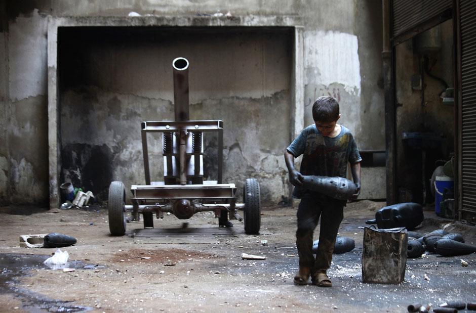 10-летний Исса несет мину на орудийном заводе Свободной сирийской армии в Алеппо. 7 сентября 2013 г. Reuters / Hamid Khatib.