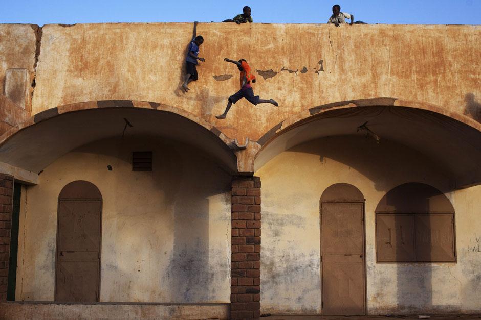 Мальчики играют на крыше футбольного стадиона. Мали. 20 февраля 2013 г. Reuters / Joe Penney.