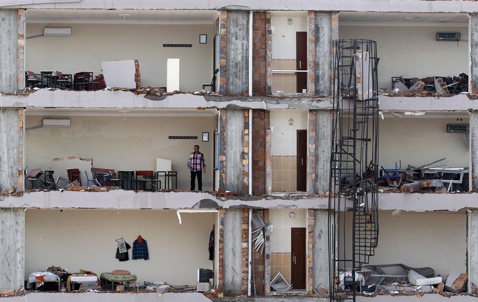 Мужчина в доме, разрушенном в результате взрыва у турецко-сирийской границы. 13 мая 2013 г. Reuters / Umit Bektas.